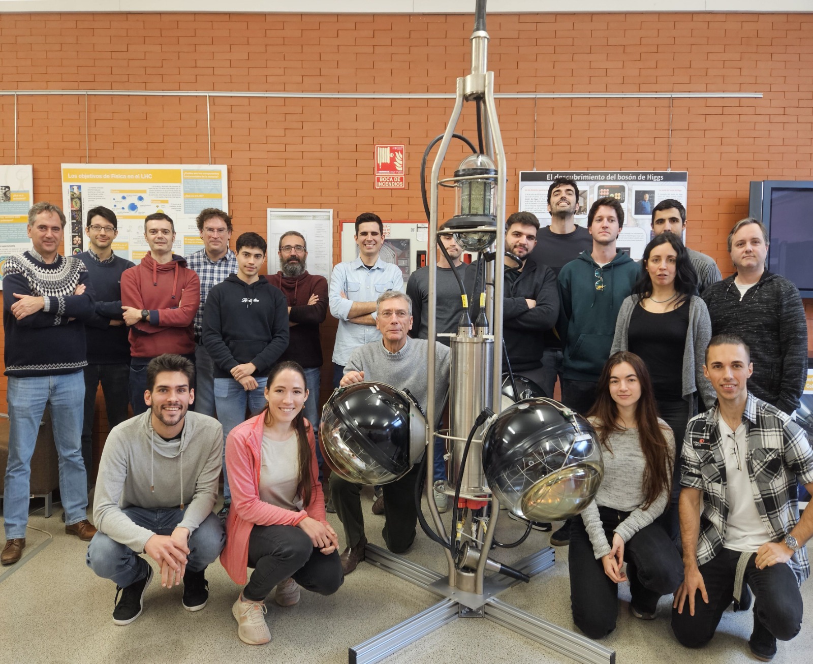 Miembros del equipo VEGA del IFIC, junto a uno de los elementos del detector ANTARES, antecesor de KM3NeT. De izquierda a  derecha, fila posterior: Juan Zúñiga, David Calvo, Francisco Salesa, Diego Real, Mario Manzaneda, Juan de Dios Zornoza, Juan  Palacios, Adrian Saina, Emilio Pastor, Alfonso García, Alfonso Lazo, Rebecca Gozzini, Vincent Cecchini, Agustín Sánchez; fila  anterior: Jorge Prado, Nadja Lessing, Juan José Hernández, Adriana Bariego, Sergio Alves.